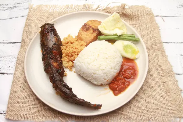 a plate of rice, with fish,vegetable and sauce