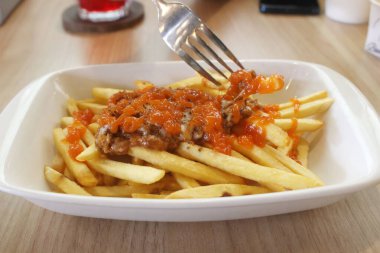 french fries with tomato sauce and cheese
