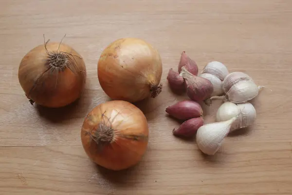 Beyaz ahşap bir masada sarımsak, soğan ve sarımsak.