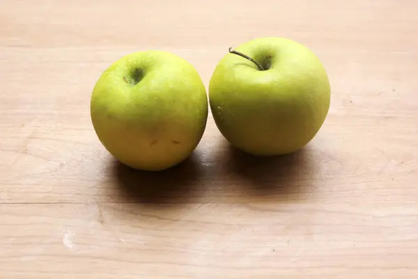 two apples lie on a white wooden surface