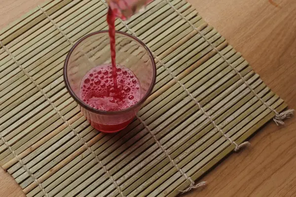 木の背景にグラスに赤いジュース — ストック写真