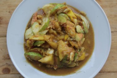 Bir tabak rujak, rujak, dilimlenmiş taze meyve biber ve esmer şekerle karıştırılmış..