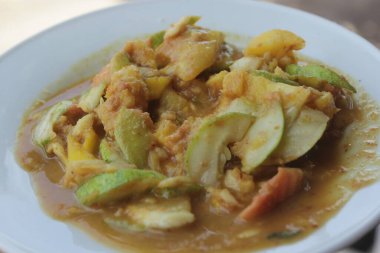 Bir tabak rujak, rujak, dilimlenmiş taze meyve biber ve esmer şekerle karıştırılmış..