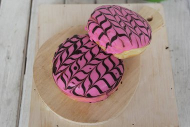 Beyaz arkaplanı olan pembe çörekler.