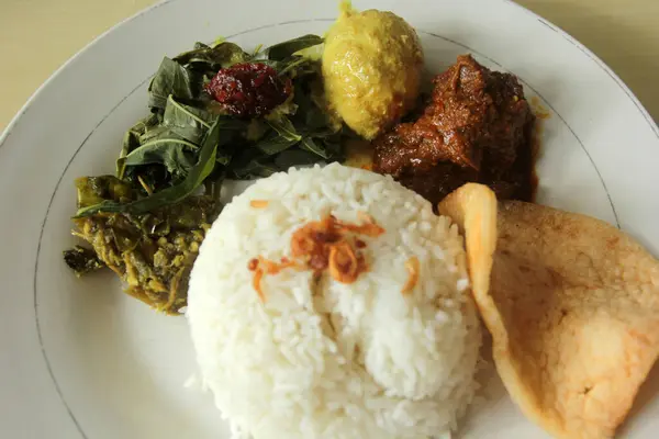 Ένα Πιάτο Ρύζι Αυγό Ρεντάνγκ Κρακεράκια Και Λαχανικά Ινδονησιακά Πιάτα — Φωτογραφία Αρχείου
