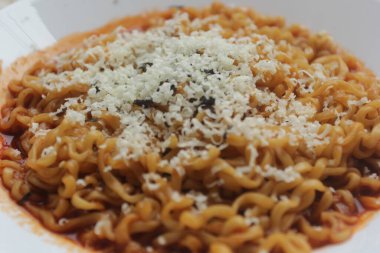 Bir tabak rendelenmiş peynirli erişte.