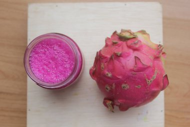 bir bardak ejderha meyve suyu ve ejderha meyvesi ahşap masada izole