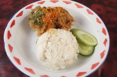 Bir tabak pilav, baharatlı tavuk ve sebze.