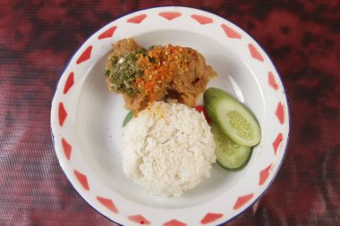 Bir tabak pilav, baharatlı tavuk ve sebze.