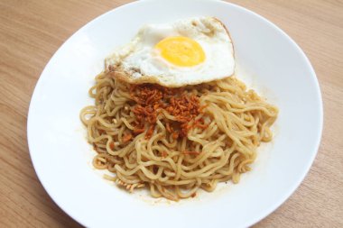 Yumurtalı hazır şehriye ve beyaz tabakta domuz eti