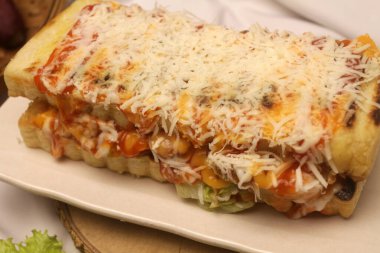 Peynirli ve jambonlu sandviç, yakın çekim manzaralı.