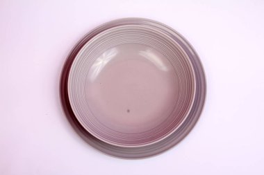Mor pastel arka planda boş beyaz tabak.