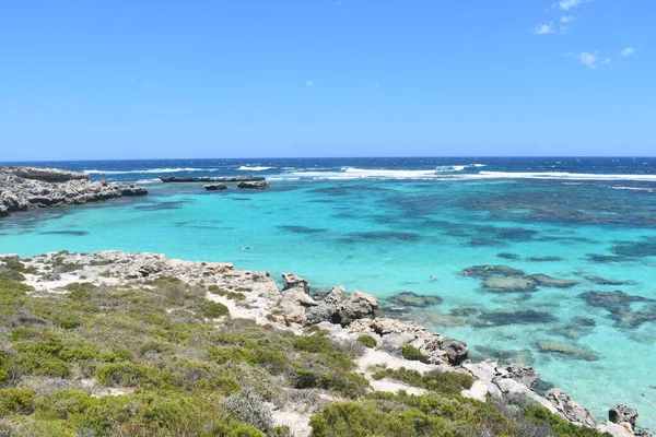 Rottnest Adası, Batı Avustralya. Doğadaki Dinginlik: berrak mavi su, kayalık sahil ve güneşli gökyüzü ile sakin koy.