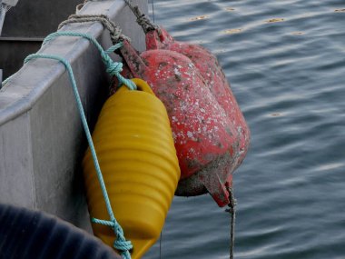 Sarı ve kırmızı şamandıralar bir gemiden sarkıyor