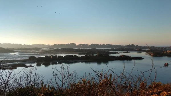 Perros Guirrec, Brittany 'deki pembe granit sahilde gün batımında rüya gibi bir atmosfer.