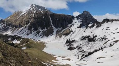 İlkbaharda Lessy Gölü 'nün videosu, dağların karla kaplı olduğu ve Haute Savoie' deki Alp Gölü 'nün Bornes Aravis' in kütlelerinde ele geçirildiği.