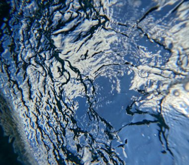 Gökyüzünün deniz altı görüntüsü, deniz yüzeyinin altı, soyut sıvı arkaplan. Suyun altındaki bulutlarla gökyüzünün alışılmadık görüntüsü