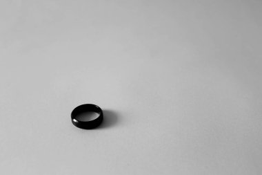 Beyaz arkaplanda küçük siyah yüzüğün monokrom tarzı resmi