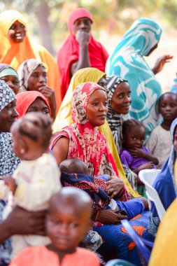 Abuja, Nijerya - 26 Şubat 2023: Covid 19 Toplum Duyarlılığı, Sağlık ve Su Hijyeni. Afrikalılar oturuyor, kuyruğa giriyor ve ücretsiz tıbbi yardım bekliyorlar. Afrika 'daki Seçim Süreci.