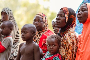 Abuja, Nijerya - 26 Şubat 2023: Covid 19 Toplum Duyarlılığı, Sağlık ve Su Hijyeni. Afrikalılar oturuyor, kuyruğa giriyor ve ücretsiz tıbbi yardım bekliyorlar. Afrika 'daki Seçim Süreci.
