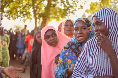 Abuja, Nijerya - 26 Şubat 2023: Covid 19 Toplum Duyarlılığı, Sağlık ve Su Hijyeni. Afrikalılar oturuyor, kuyruğa giriyor ve ücretsiz tıbbi yardım bekliyorlar. Afrika 'daki Seçim Süreci.