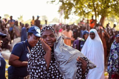 Abuja, Nijerya - 26 Şubat 2023: Covid 19 Toplum Duyarlılığı, Sağlık ve Su Hijyeni. Afrikalılar oturuyor, kuyruğa giriyor ve ücretsiz tıbbi yardım bekliyorlar. Afrika 'daki Seçim Süreci.
