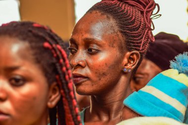 Abuja, Nijerya - 10 Şubat 2021: Afrikalılar kırsal kesimde oturuyor, kuyruğa giriyor ve ücretsiz tıbbi bakım ve ilgi bekliyorlar. Seçimlerde oy kullanmak için kaydolurlar. Siyasi Kampanya Egzersizi