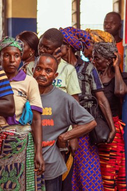 Abuja, Nijerya - 10 Şubat 2021: Afrikalılar kırsal kesimde oturuyor, kuyruğa giriyor ve ücretsiz tıbbi bakım ve ilgi bekliyorlar. Seçimlerde oy kullanmak için kaydolurlar. Siyasi Kampanya Egzersizi