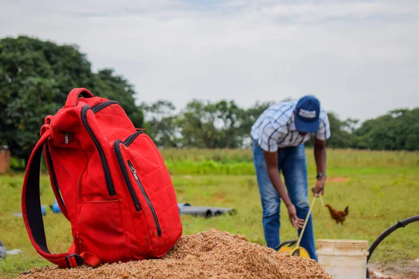 Nigeria June 2023 Man Working African Village Red Backpack Foreground — Stock Photo, Image