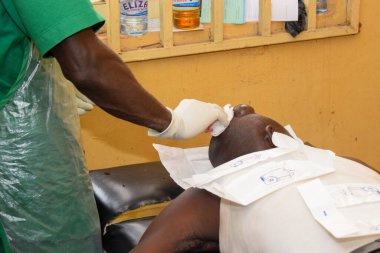 Edo State, Nijerya - 25 Aralık 2021: Başarılı bir ameliyattan sonra Afrikalı adam kırsal bir klinikte iyileşiyor