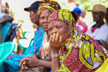 Abuja, Nijerya - 20 Aralık 2021: Afrikalılar kırsal kesimde ücretsiz tıbbi bakım ve dikkat kuyruğunda beklerken oturuyorlar. Afrika 'daki Siyasi Kampanya