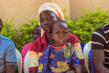 Edo Eyaleti, Nijerya - 10 Ağustos 2021: Afrikalılar kırsal kesimde oturuyor, kuyruğa giriyor ve ücretsiz tıbbi bakım ve ilgi bekliyorlar