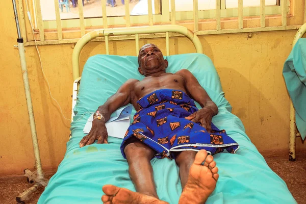 stock image Edo State - December 25, 2021: Elderly African Man Recovering on a Sick Bed in a rural clinic After a Successful Surgery