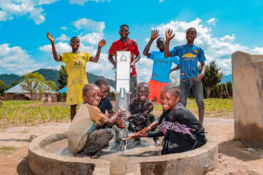 Abuja, Nigeria - August 02, 2021: African Children Having Fun as they Express Happiness and Laughter while Playing with Clean Water under the Sun in a Rural Community. Joyful and Grateful Children clipart