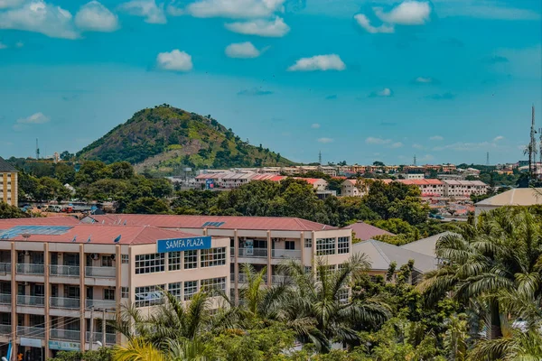 Abuja, Nijerya - 01 Temmuz 2022: Abuja Şehir Merkezi. Şehir manzarası Blue Sky ve Hills ile sınırlandırılmış. Doğa tarafından çevrili binaların kesitleri. Metropolis 'te Ağaç Dikme.