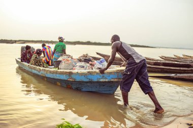 Delta State, Nijerya - 9 Aralık 2021: Afrika topluluklarında su taşımacılığı. Afrika nehirlerinin ticari kullanımı. Kırsal çevrede alım satım. Afrika Köylerinde Balıkçılık.