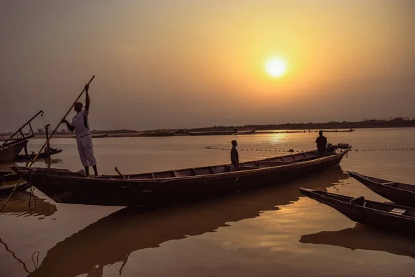 stock image Delta State, Nigeria - December 9, 2021: Locally made Canoes by a Riverside on River Niger offsetting a beautiful Sunrise. Fishing Boats by a River Bank. Reflection on a Water Surface.