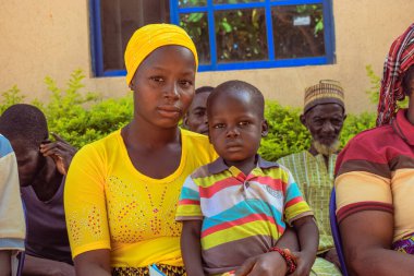 Edo Eyaleti, Nijerya - 10 Ağustos 2021: Afrikalılar kırsal kesimde oturuyor, kuyruğa giriyor ve ücretsiz tıbbi bakım ve ilgi bekliyorlar