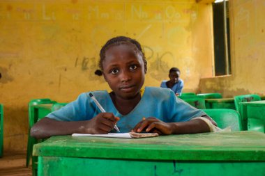 Abuja, Nijerya - 6 Haziran 2022: Kırsal Toplulukta Öğrenen Afrikalı Bir Çocuğun Portresi. Sınıfta üniforma giyen gülümseyen Afrikalı çocuklar. Afrika Köylerinde İlköğretim.