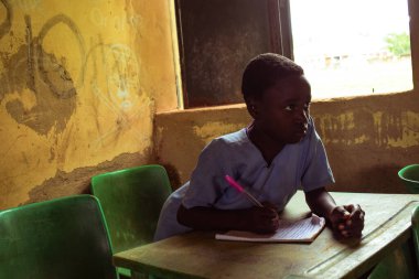 Abuja, Nijerya - 6 Haziran 2022: Kırsal Toplulukta Öğrenen Afrikalı Bir Çocuğun Portresi. Sınıfta üniforma giyen gülümseyen Afrikalı çocuklar. Afrika Köylerinde İlköğretim.