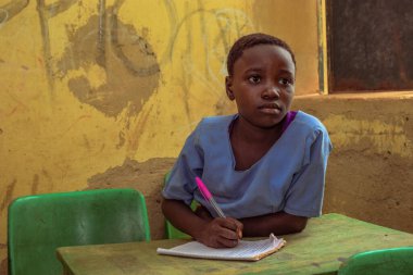 Abuja, Nijerya - 6 Haziran 2022: Kırsal Toplulukta Öğrenen Afrikalı Bir Çocuğun Portresi. Sınıfta üniforma giyen gülümseyen Afrikalı çocuklar. Afrika Köylerinde İlköğretim.