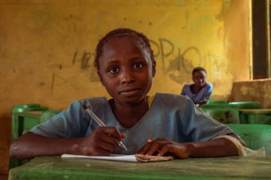 Abuja, Nijerya - 6 Haziran 2022: Kırsal Toplulukta Öğrenen Afrikalı Bir Çocuğun Portresi. Sınıfta üniforma giyen gülümseyen Afrikalı çocuklar. Afrika Köylerinde İlköğretim.