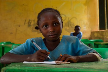 Abuja, Nijerya - 6 Haziran 2022: Kırsal Toplulukta Öğrenen Afrikalı Bir Çocuğun Portresi. Sınıfta üniforma giyen gülümseyen Afrikalı çocuklar. Afrika Köylerinde İlköğretim.