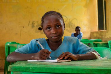 Abuja, Nijerya - 6 Haziran 2022: Kırsal Toplulukta Öğrenen Afrikalı Bir Çocuğun Portresi. Sınıfta üniforma giyen gülümseyen Afrikalı çocuklar. Afrika Köylerinde İlköğretim.