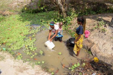 Karara, Nasarawa Eyaleti - 5 Mayıs 2021: Bebekli Afrikalı Kadın Günlük Tüketimleri için Gölden Kirli ve Kirli Suyu Getirdi