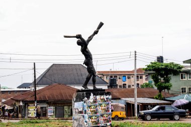 Enugu, Enugu Eyaleti - 06 Mayıs 2021: Storey Binaları Obiagwu kavşağıyla çevrili büyük bir kavşakta bir kasaba krateri heykeli