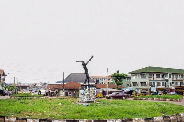 Enugu, Enugu Eyaleti - 06 Mayıs 2021: Storey Binaları Obiagwu kavşağıyla çevrili büyük bir kavşakta bir kasaba krateri heykeli