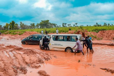 Loko, Nasarawa, Nijerya - 06 Ağustos 2021: Yağmur mevsiminde çamurlu yol. Araçlar kötü yola saplandı ve kazaya neden oldu..