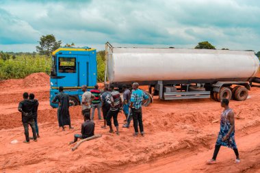 Loko, Nasarawa, Nijerya - 06 Ağustos 2021: Yağmur mevsiminde çamurlu yol. Araçlar kötü yola saplandı ve kazaya neden oldu..