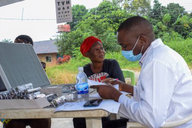 Aluu, Port Harcourt - 10 Ağustos 2021: Bir kırsal kesimde ücretsiz tıbbi bakım ve bakım bekleyen Afrikalılar. Seçimlerde oy kullanmak için kaydolurlar. Siyasi Kampanya Egzersizi